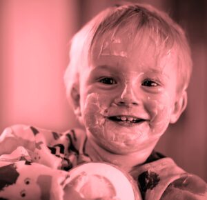 toddler with yogurt on his face